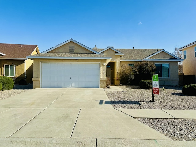 ranch-style house with a garage, driveway, and stucco siding