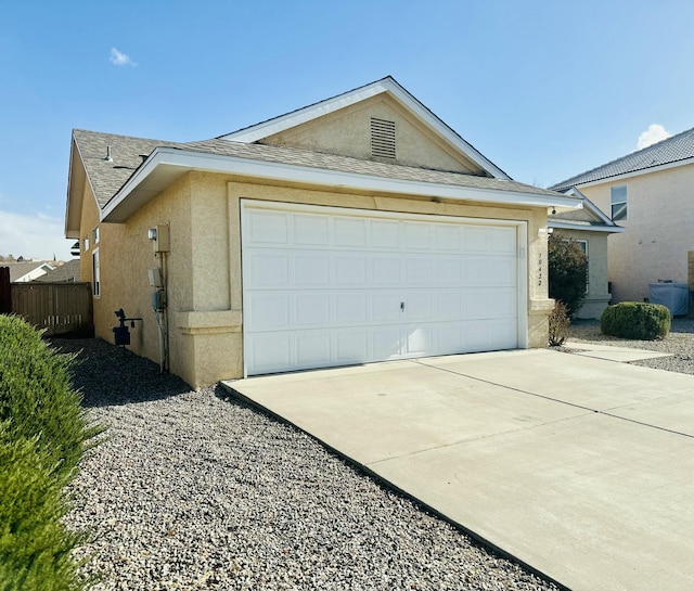 exterior space featuring a garage, roof with shingles, and stucco siding