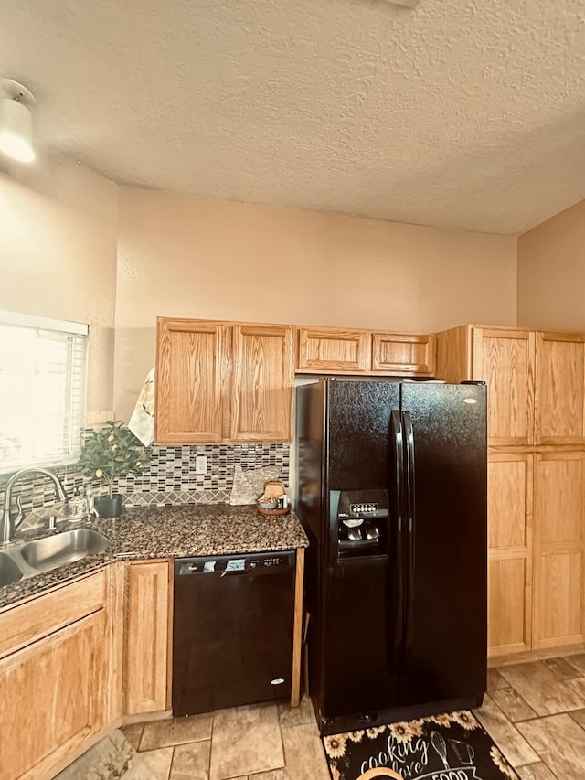 kitchen featuring light brown cabinets, black appliances, tasteful backsplash, and a sink