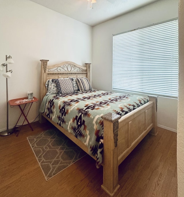 bedroom with a ceiling fan, baseboards, and wood finished floors