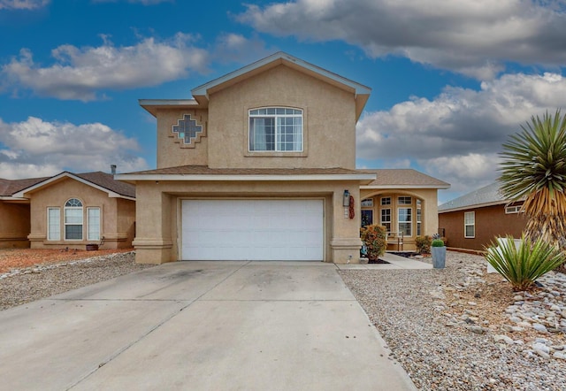 traditional-style house with stucco siding, a garage, and driveway