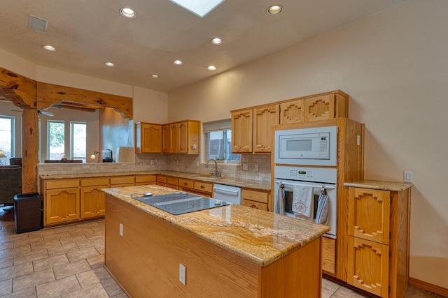 kitchen with a center island, decorative backsplash, a sink, white appliances, and a peninsula