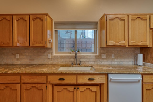 kitchen featuring dishwasher, backsplash, a sink, and light stone countertops