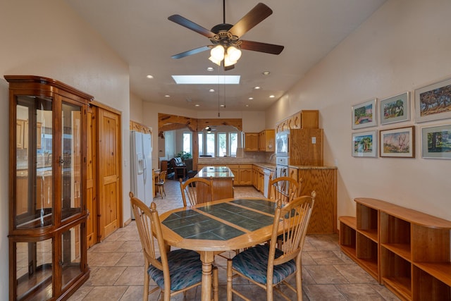 dining room with a ceiling fan, recessed lighting, and a skylight