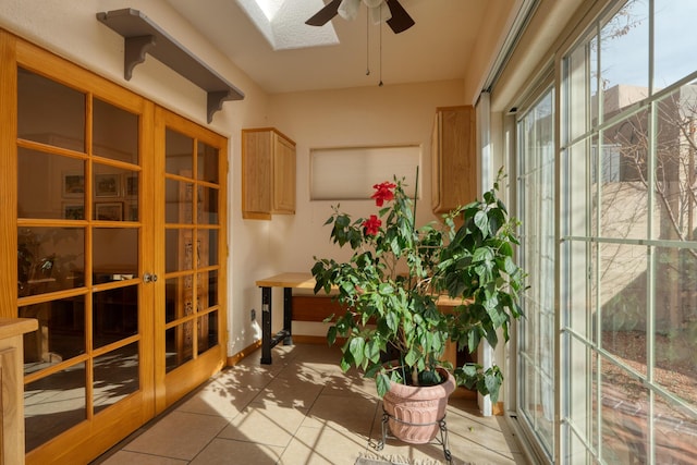 sunroom with a skylight, french doors, and ceiling fan