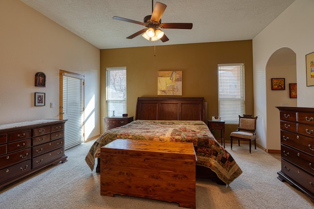 bedroom with light carpet, baseboards, a ceiling fan, and a textured ceiling