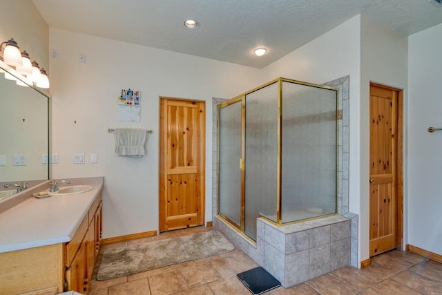 full bath featuring a stall shower, vanity, and baseboards