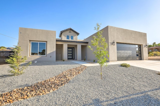 view of front of property with driveway, an attached garage, and stucco siding