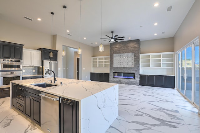 kitchen featuring marble finish floor, a fireplace, stainless steel appliances, visible vents, and a sink