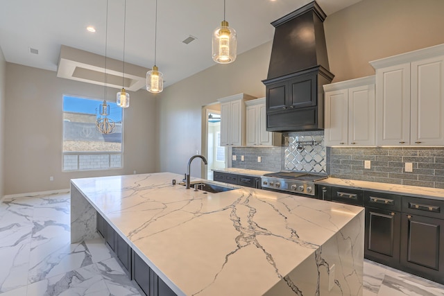 kitchen with a large island, backsplash, white cabinetry, a sink, and light stone countertops