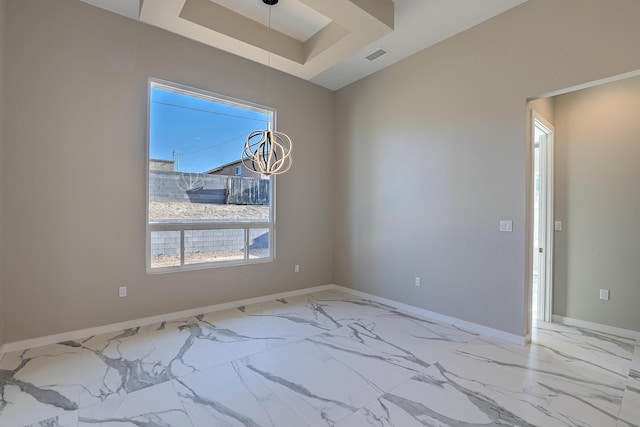 empty room with marble finish floor, a raised ceiling, visible vents, an inviting chandelier, and baseboards