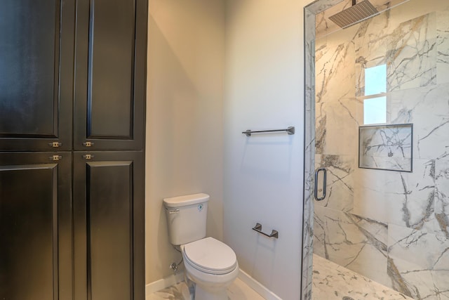 bathroom with baseboards, toilet, and a marble finish shower