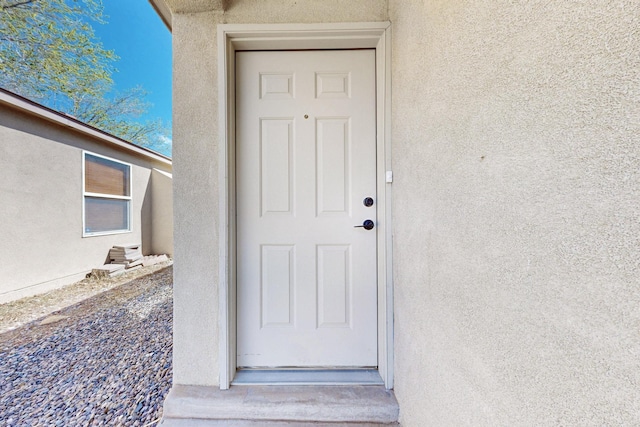 property entrance with stucco siding