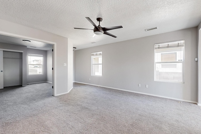 unfurnished bedroom featuring visible vents, baseboards, carpet, and a ceiling fan