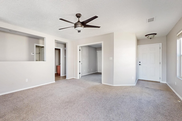 empty room featuring visible vents, baseboards, ceiling fan, carpet flooring, and a textured ceiling