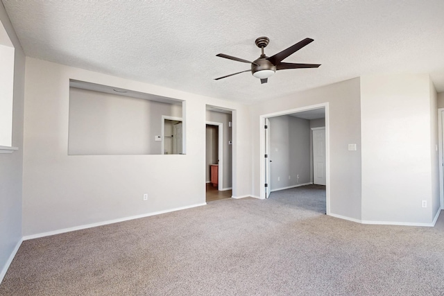 carpeted spare room featuring baseboards, a textured ceiling, and a ceiling fan