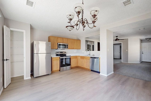 kitchen with light countertops, visible vents, appliances with stainless steel finishes, and a sink