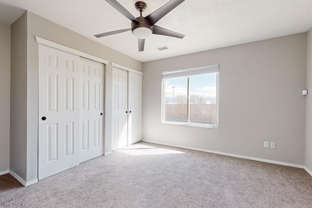 unfurnished bedroom with visible vents, two closets, baseboards, carpet, and a ceiling fan