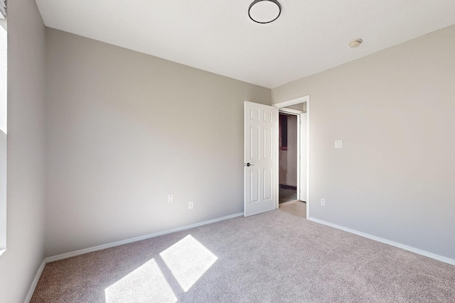 empty room with baseboards and carpet