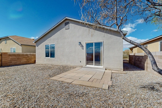 back of property featuring stucco siding, a patio, and a fenced backyard