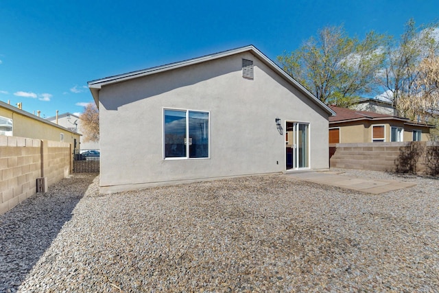 back of house featuring stucco siding, a patio, and a fenced backyard