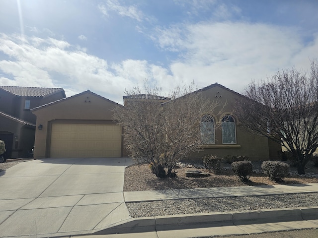 view of front of home with an attached garage, driveway, and stucco siding