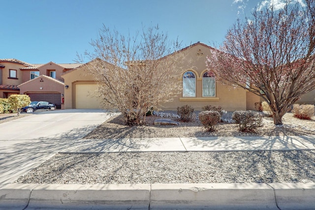 view of front of house featuring stucco siding, a garage, concrete driveway, and a tile roof