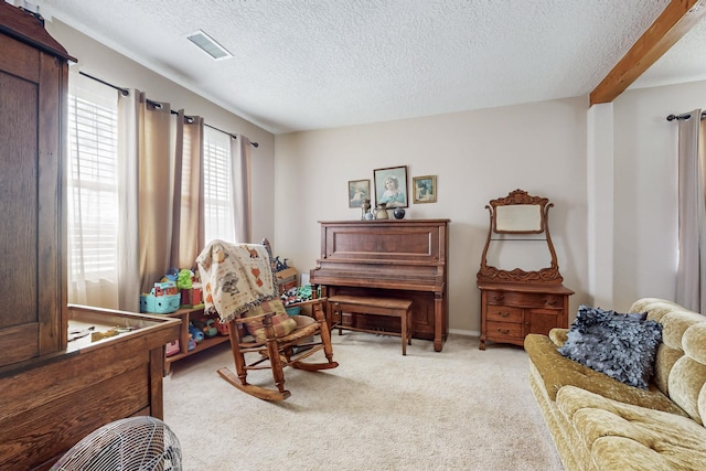 living area featuring a textured ceiling, visible vents, and light carpet