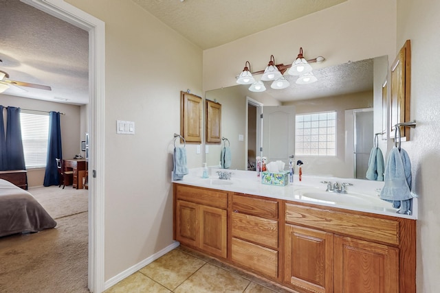 ensuite bathroom featuring a sink, a textured ceiling, ensuite bath, and tile patterned flooring