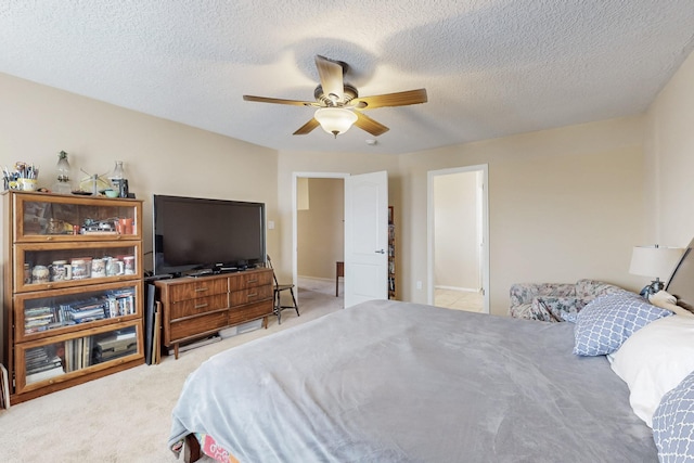 carpeted bedroom with a ceiling fan and a textured ceiling