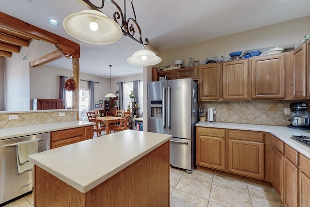 kitchen featuring light countertops, tasteful backsplash, and appliances with stainless steel finishes