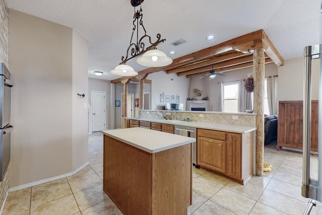 kitchen with a ceiling fan, visible vents, a kitchen island, stainless steel appliances, and light countertops