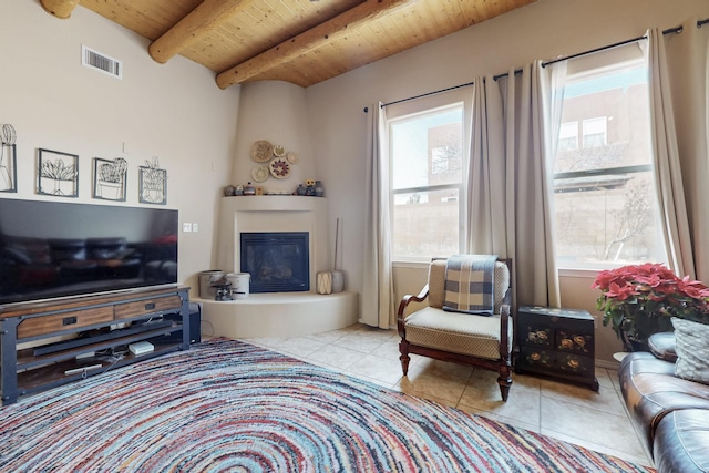 tiled living area with beam ceiling, wooden ceiling, visible vents, and a large fireplace