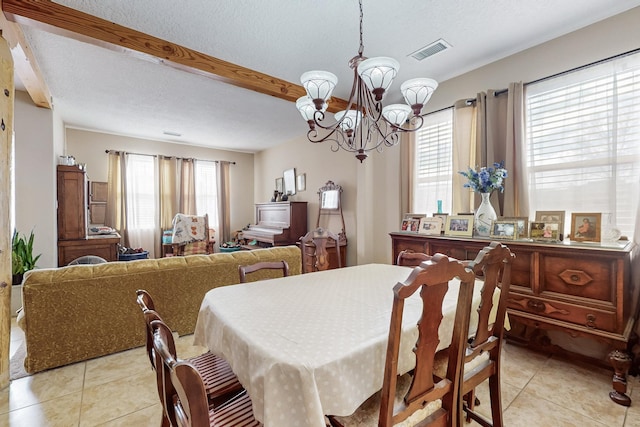 dining room with a notable chandelier, visible vents, a textured ceiling, and light tile patterned flooring