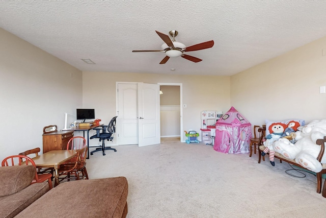 carpeted office featuring a textured ceiling and a ceiling fan