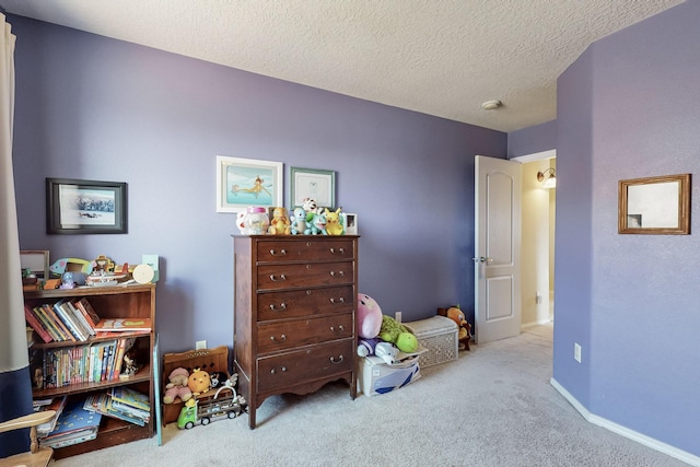 bedroom with carpet, baseboards, and a textured ceiling