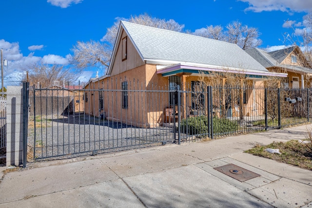 view of front facade with roof with shingles and a fenced front yard