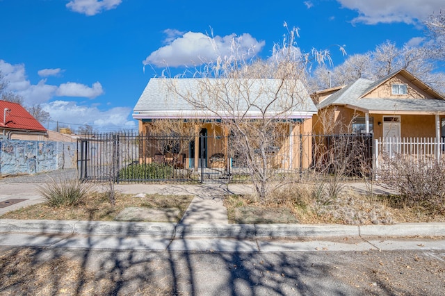 view of front of home with a fenced front yard and stucco siding