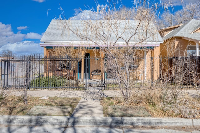 view of front of house with a fenced front yard, a gate, and stucco siding