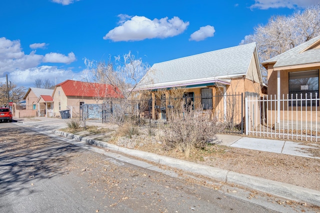 view of front facade with fence and stucco siding