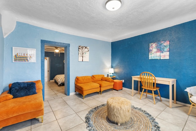 living room featuring a textured ceiling, tile patterned flooring, and baseboards