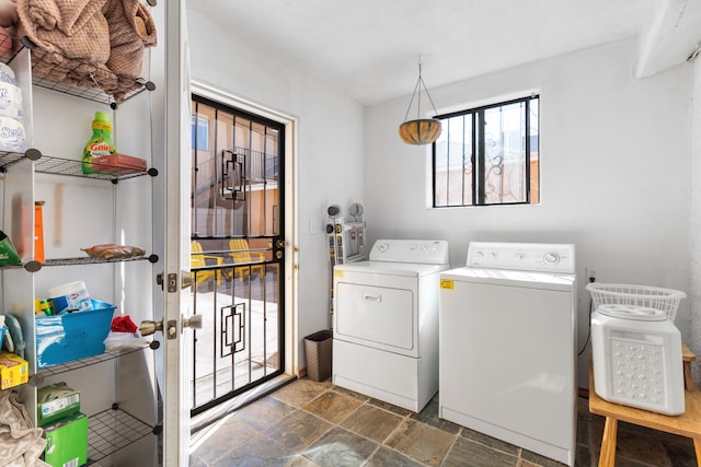 laundry area featuring washing machine and dryer, laundry area, and stone finish flooring