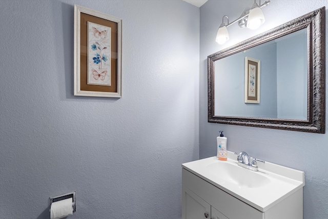 bathroom featuring a textured wall and vanity