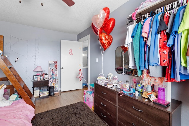 bedroom featuring a textured ceiling, wood finished floors, and a ceiling fan