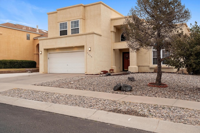 adobe home with concrete driveway, an attached garage, and stucco siding