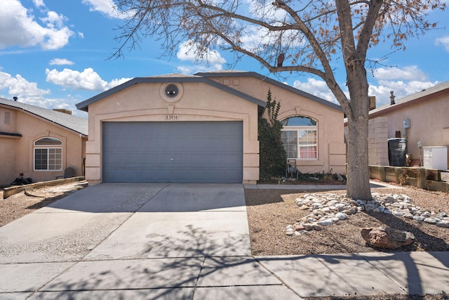 view of front facade with a garage, driveway, and stucco siding