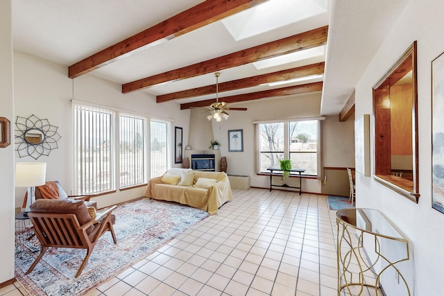 bedroom with a skylight, a large fireplace, beamed ceiling, and light tile patterned floors