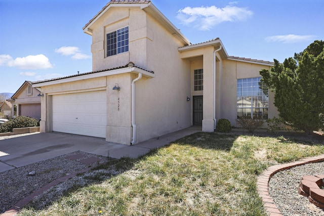view of front of home featuring a tile roof, stucco siding, and driveway