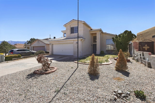 traditional home with driveway, stucco siding, and a tile roof