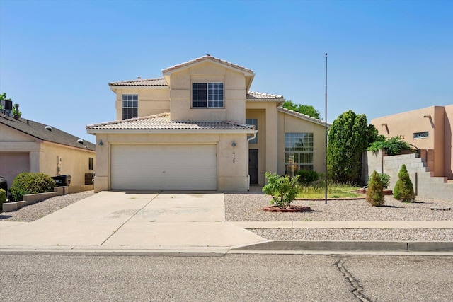 mediterranean / spanish-style home featuring stucco siding, a garage, concrete driveway, and a tiled roof